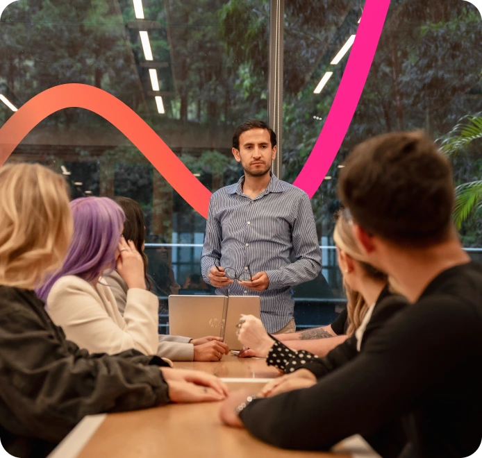 A team meeting around a conference table in a modern office.