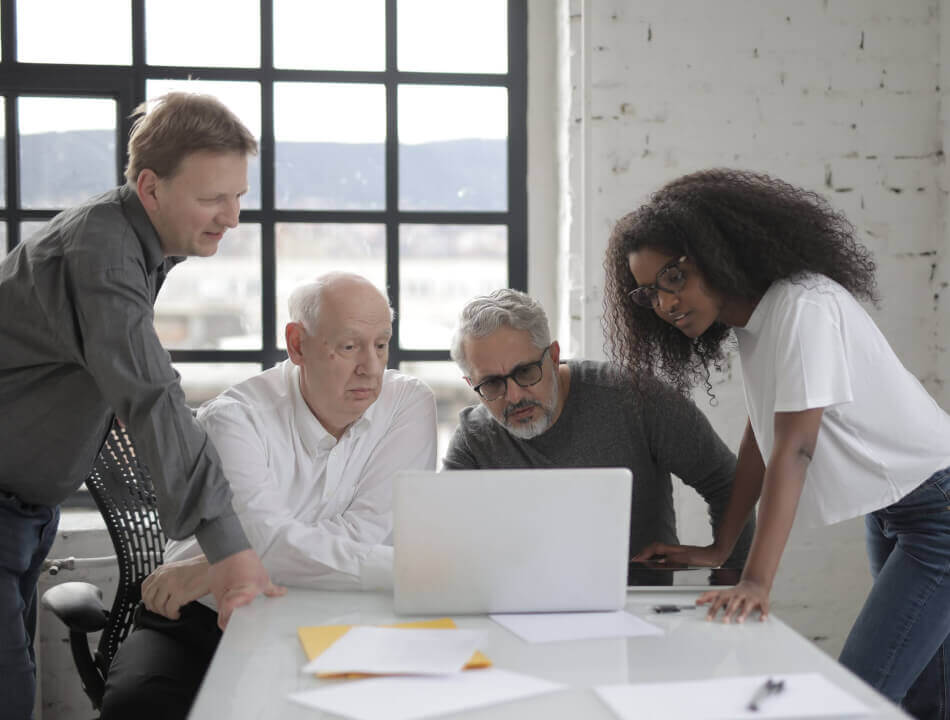 A team reviewing a laptop together in an office.