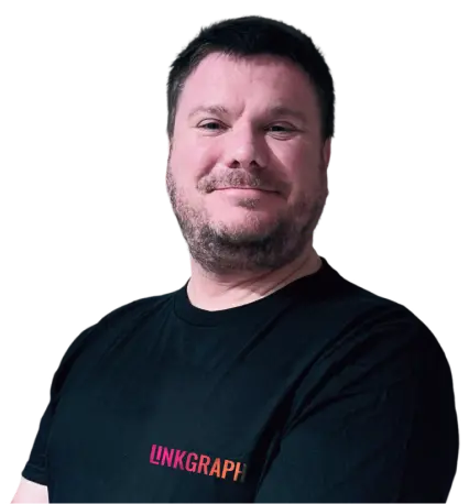 A man with short dark hair and a beard is standing with arms crossed, wearing a black T-shirt that has the word "LINKGRAPH" printed on it.