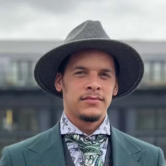 Man in stylish attire wearing a hat and patterned scarf, representing modern professionalism and brand authority in the context of AI-driven searches.