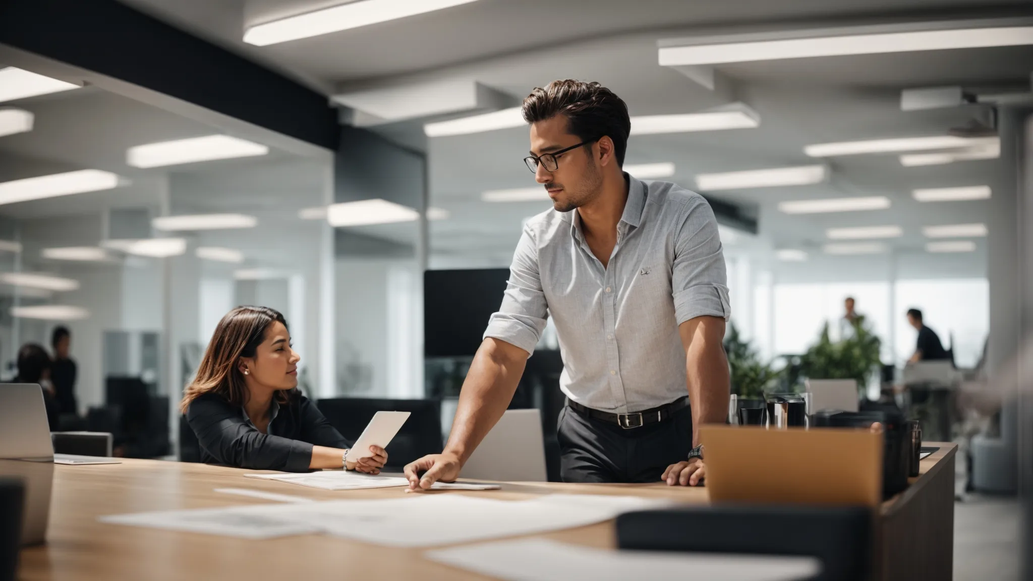 two professional individuals engaging in an attentive discussion over a digital marketing strategy plan in a bright, modern office.