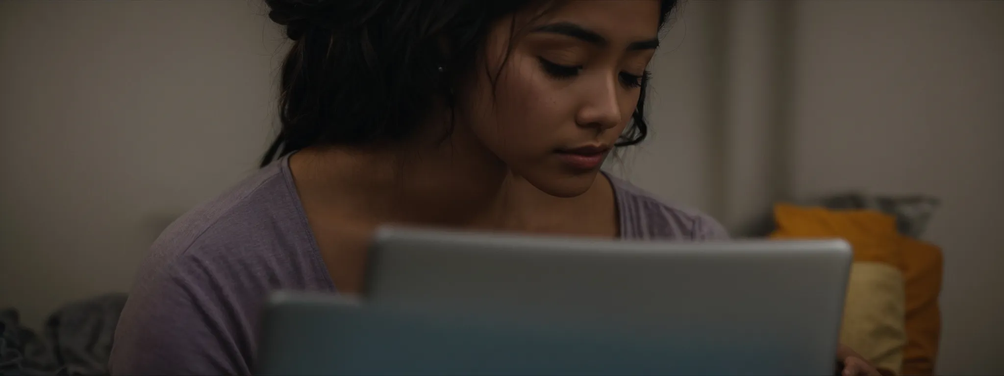 a student intently focusing on an online course displayed on a laptop.
