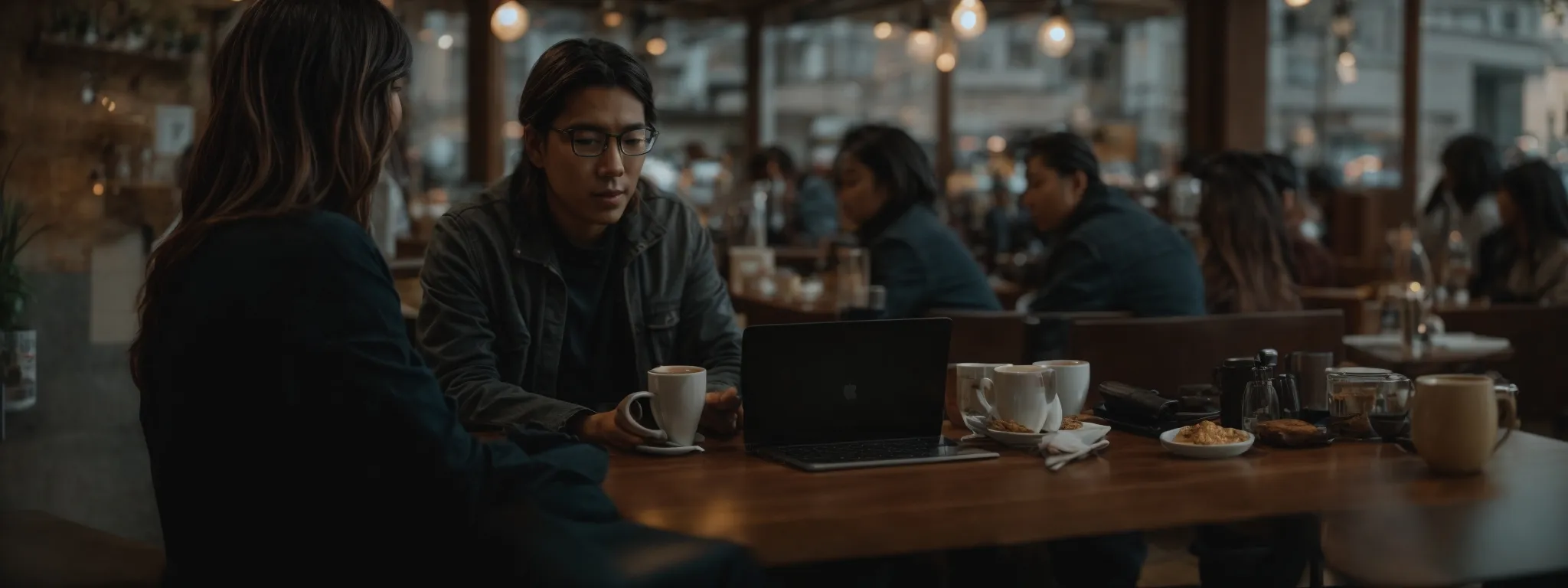 a writer sits before a laptop in a serene cafe, amidst a blend of focused individuals and steaming cups of coffee.