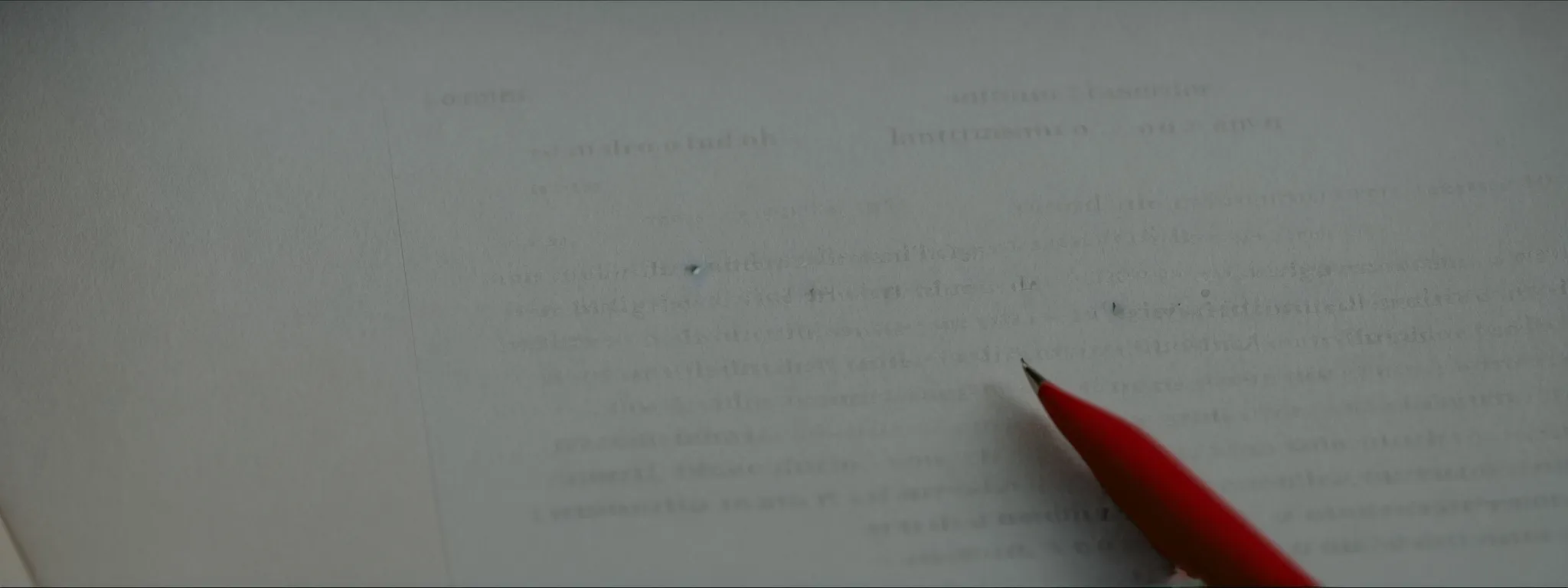 an editor meticulously examines a printout of an article with a red pen in hand.