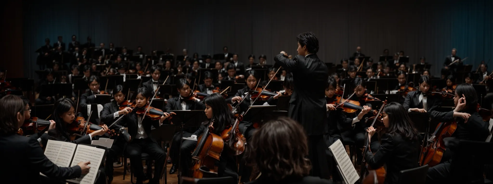 an orchestra in full performance with a focused conductor leading the ensemble.