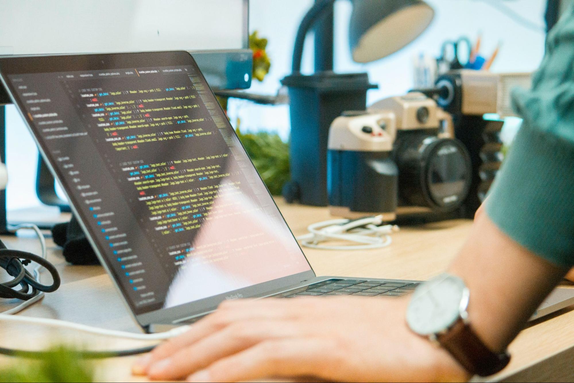  A laptop displaying code related to web development, including meta descriptions and tags and the use of semantic HTML for better search engine optimization