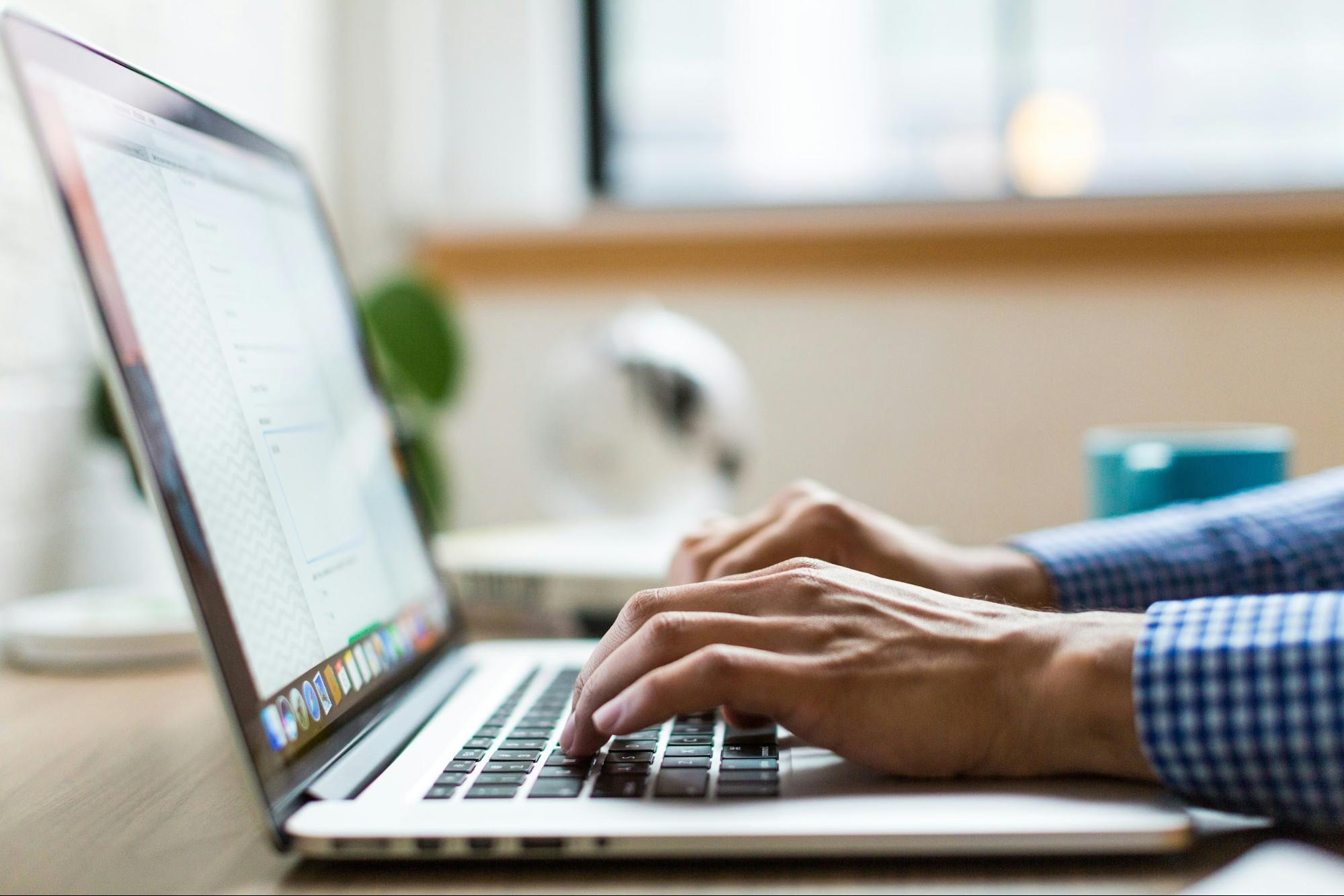 Content manager revamping old blogs on a laptop as part of cost effective SEO strategy