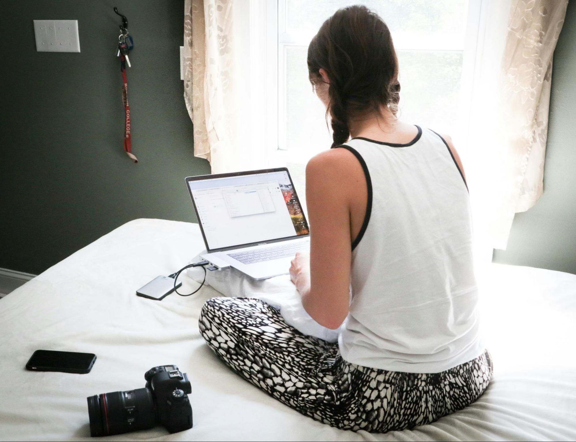 Photographer working on a laptop with a camera nearby, demonstrating how SEO services for photographers can improve online visibility and streamline business operations